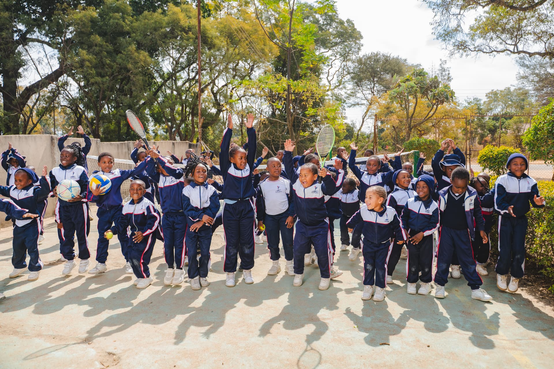 Happy junior students on tennis court