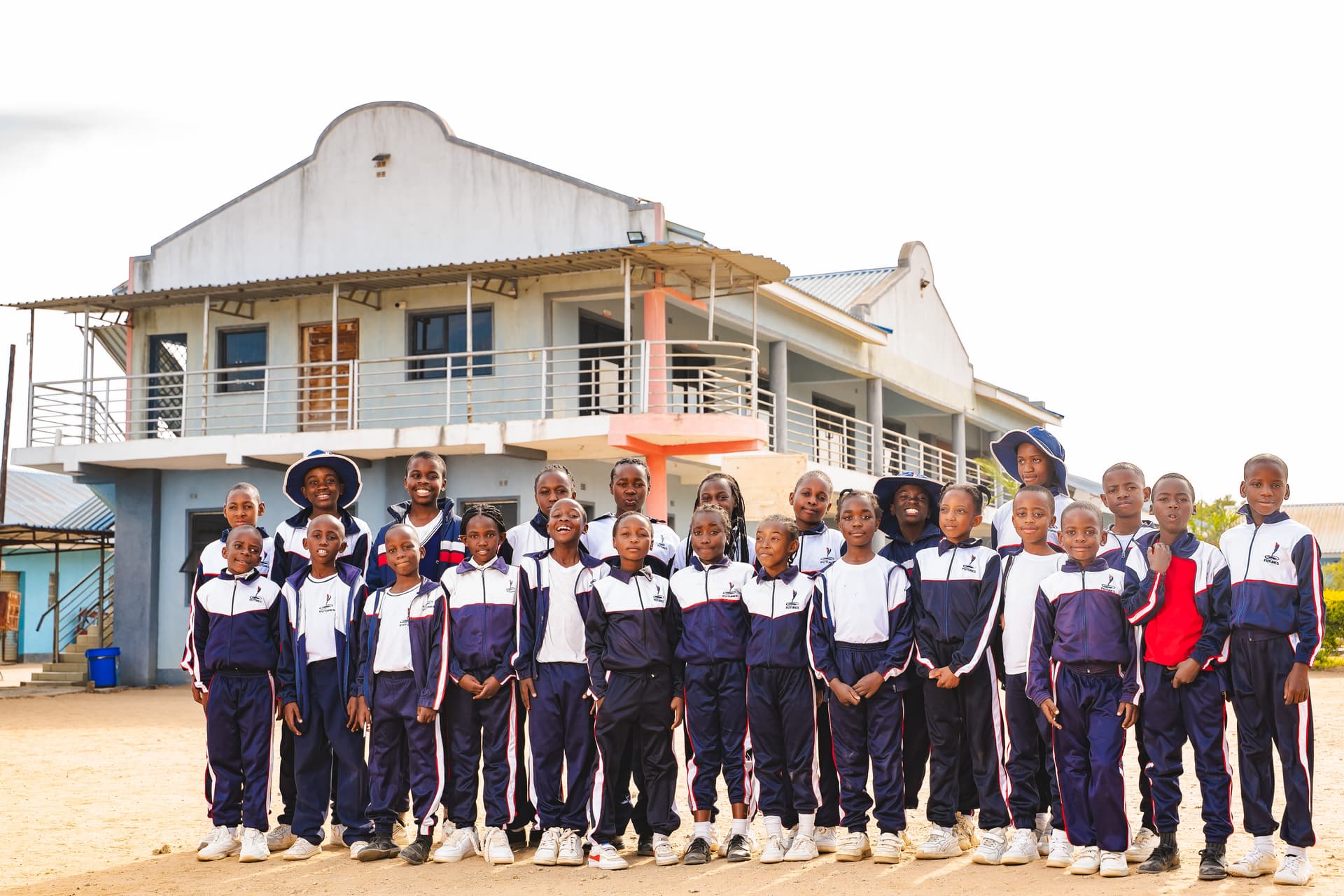 Primary students standing in front of the school